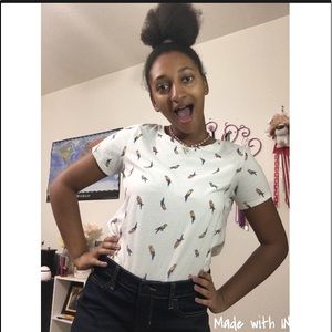 It is a short sleeve  white top with parrots on it